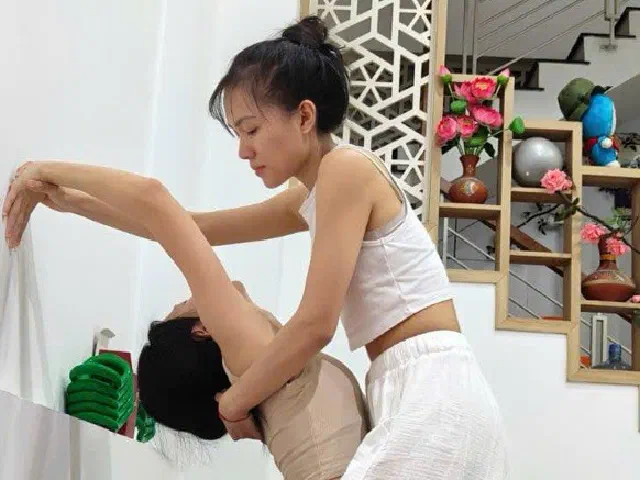 Teacher guiding a student through a backbend at Umi Yoga, Da Nang